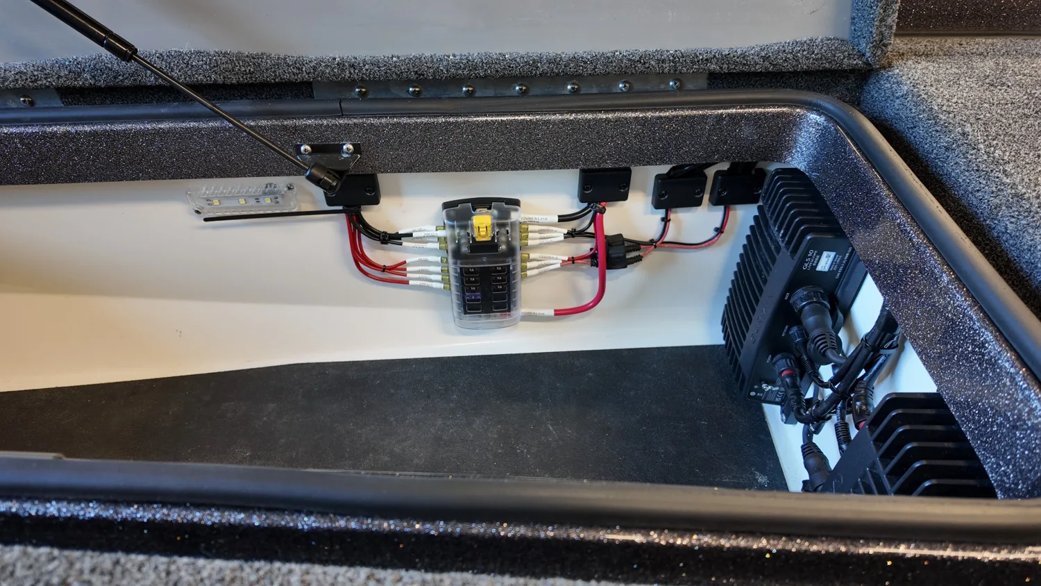 Organized electronics power distribution and protected wiring in a Caymas bass boat